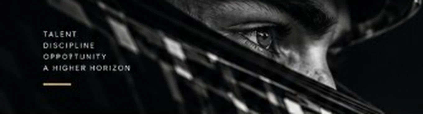 Close-up of a driver's eye through the visor. Talent, discipline, opportunity, a higher horizon.