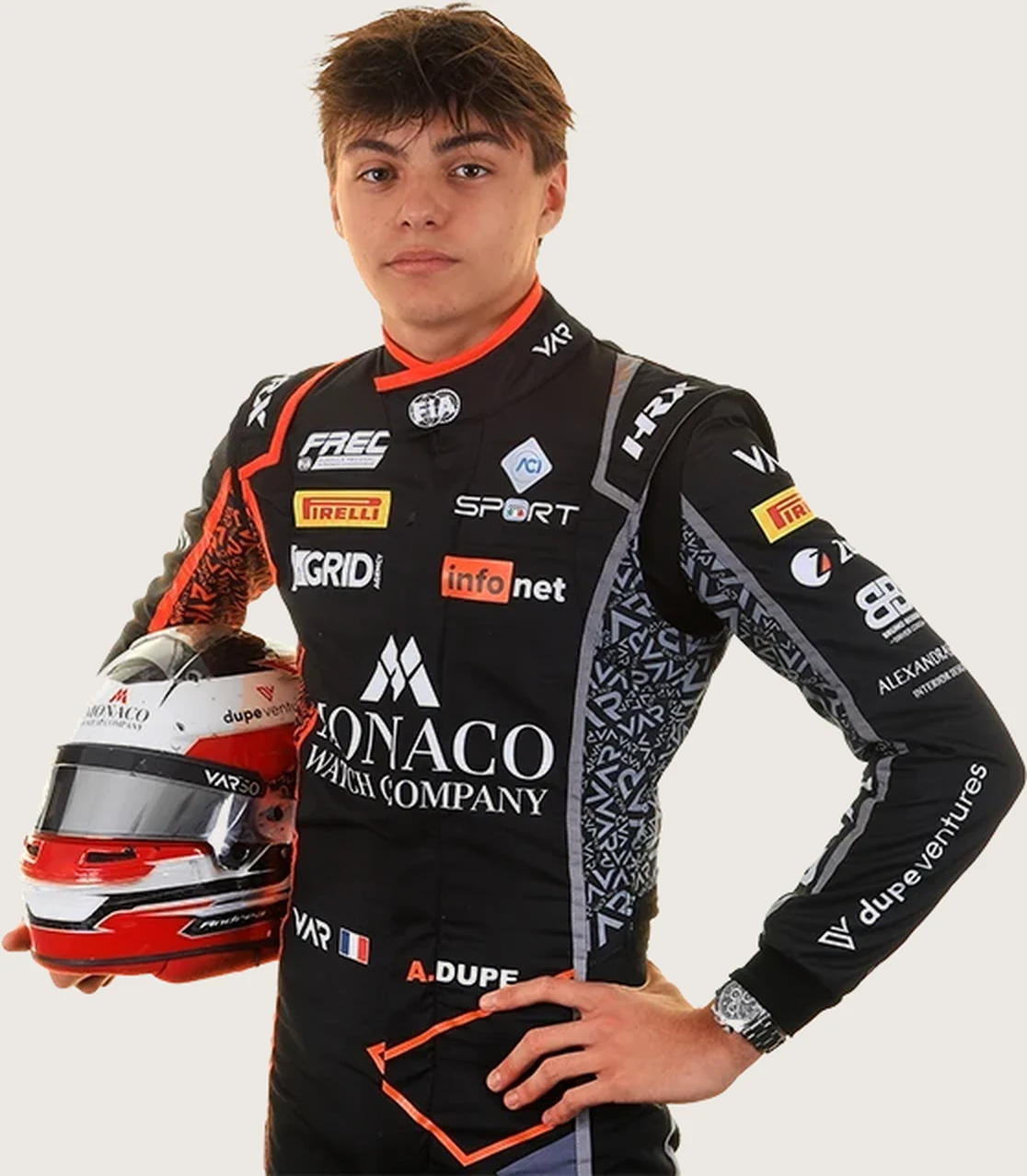 Andrea Dupé in his racing suit, holding his helmet.