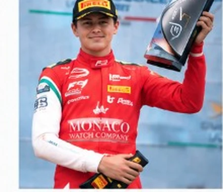 Andrea Dupé on the podium with a trophy.